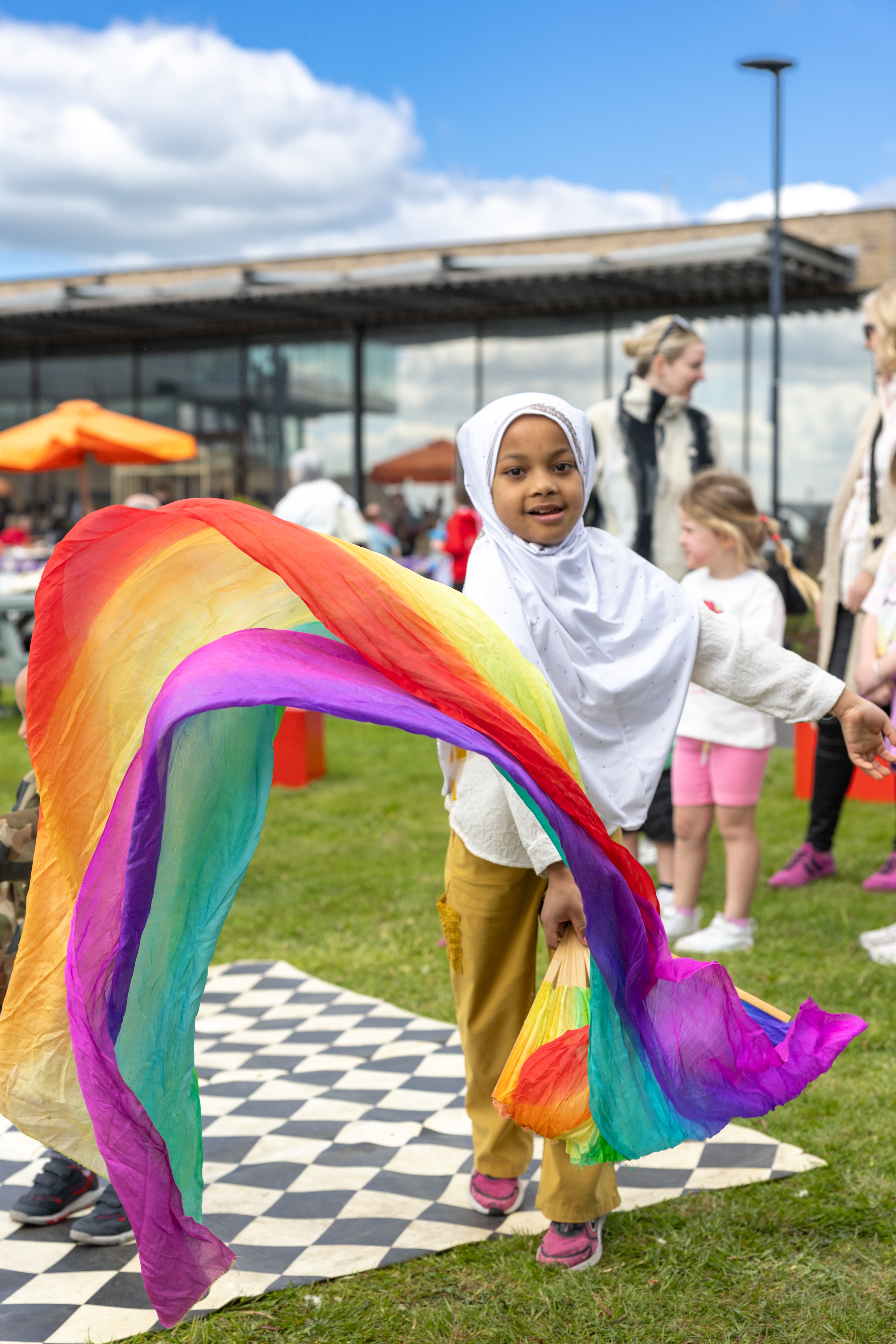 Child playing with rainbow ribbon. 